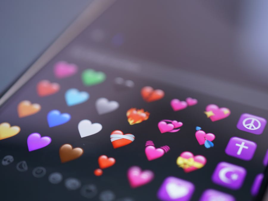 Close-up of colorful heart emojis displayed on a smartphone screen, representing digital communication.