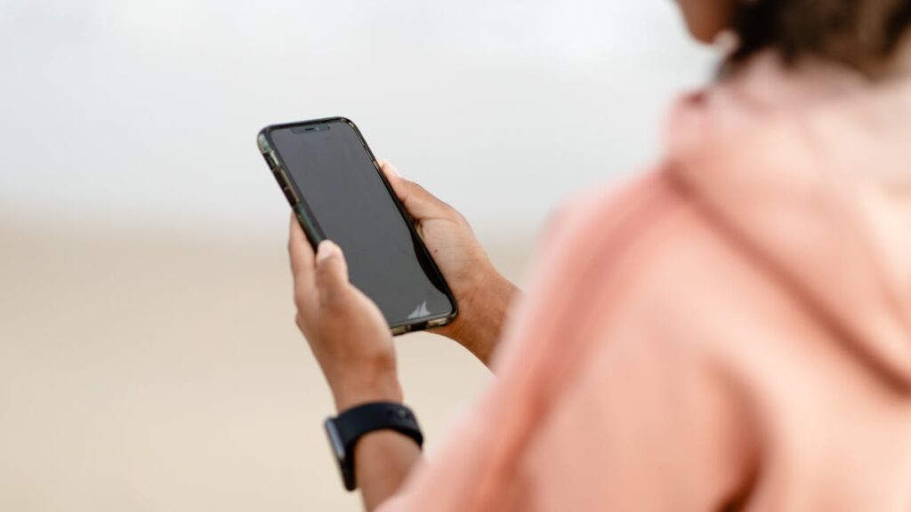 Close-up of a person using a smartphone outdoors, focusing on modern technology.