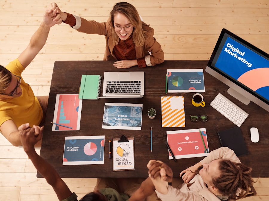Colleagues celebrating success in a modern digital marketing office with teamwork and collaboration.