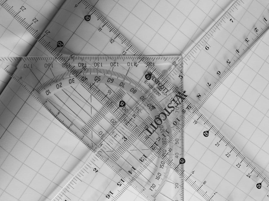 A black and white photo of geometric rulers arranged on graph paper, emphasizing precision and design.