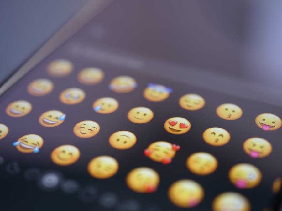 A close-up view of various emojis on a smartphone screen, symbolizing digital communication and social media use.