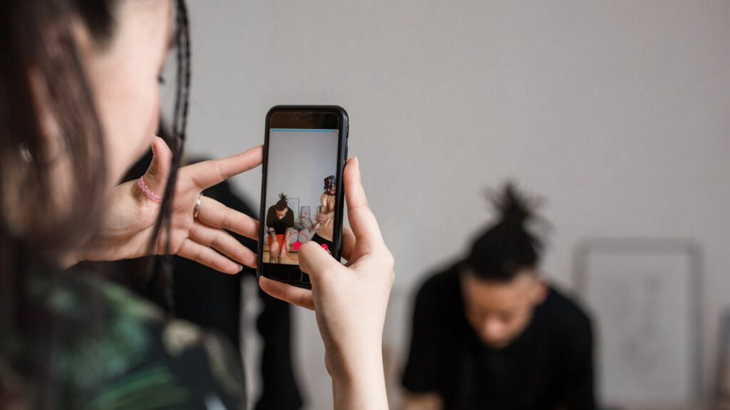 Close-up of a person recording a video with a smartphone indoors, focusing on creative content creation.