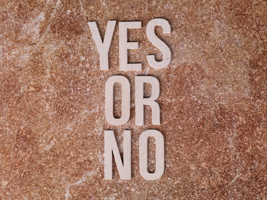 Wooden letters on marble background spell 'YES OR NO' symbolizing choices.