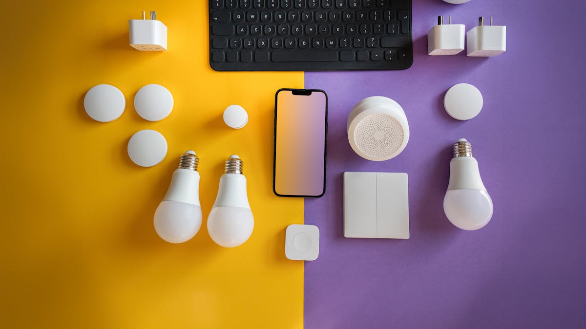 Flat lay of electronics, smart home gadgets on a colorful background for tech concepts.