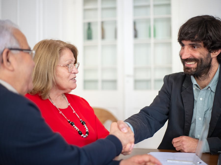 Business professionals engaged in a positive office meeting, sealing a deal with a handshake.