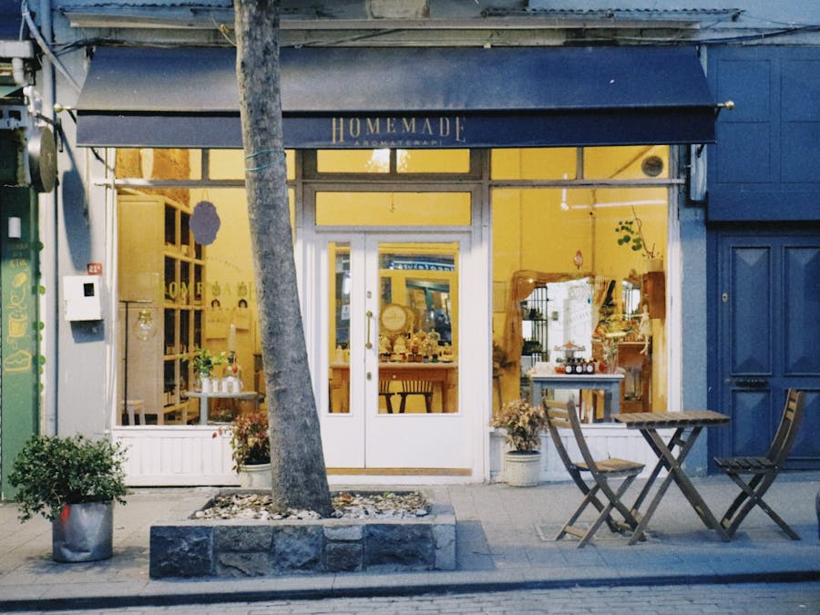 An inviting storefront displaying a cozy café with street seating in an urban setting.