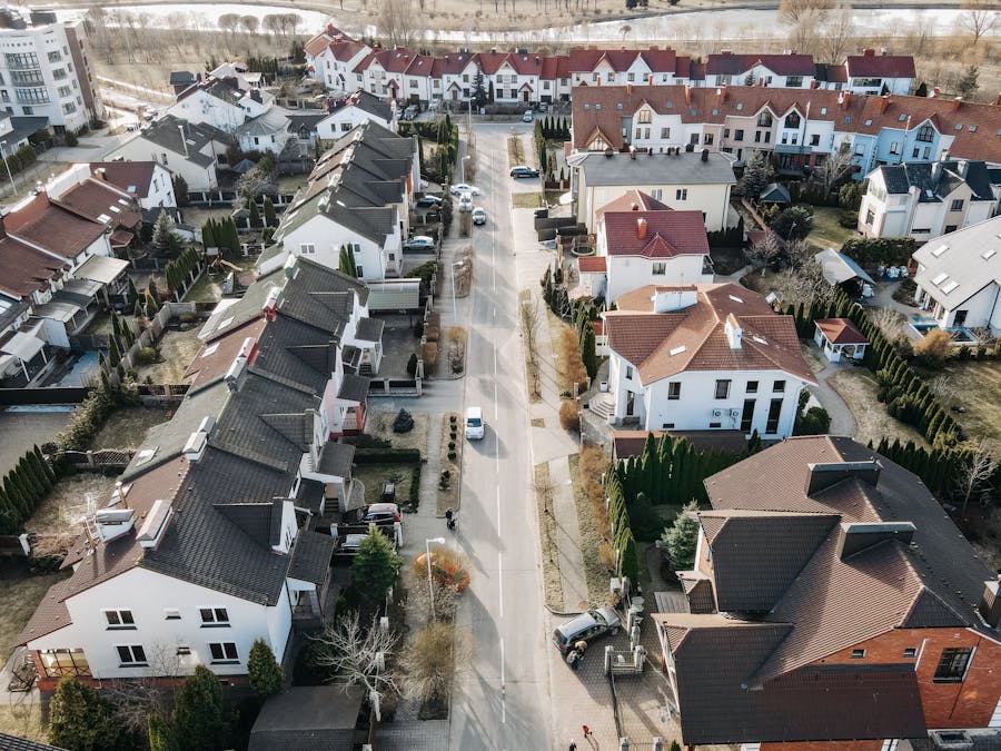 Aerial view of a suburban neighborhood with houses, streets, and cars.