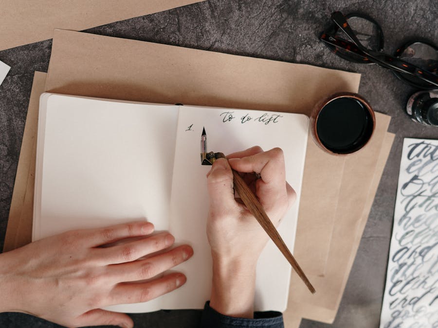 Top view of a to-do list with calligraphy pen on a desk with ink.