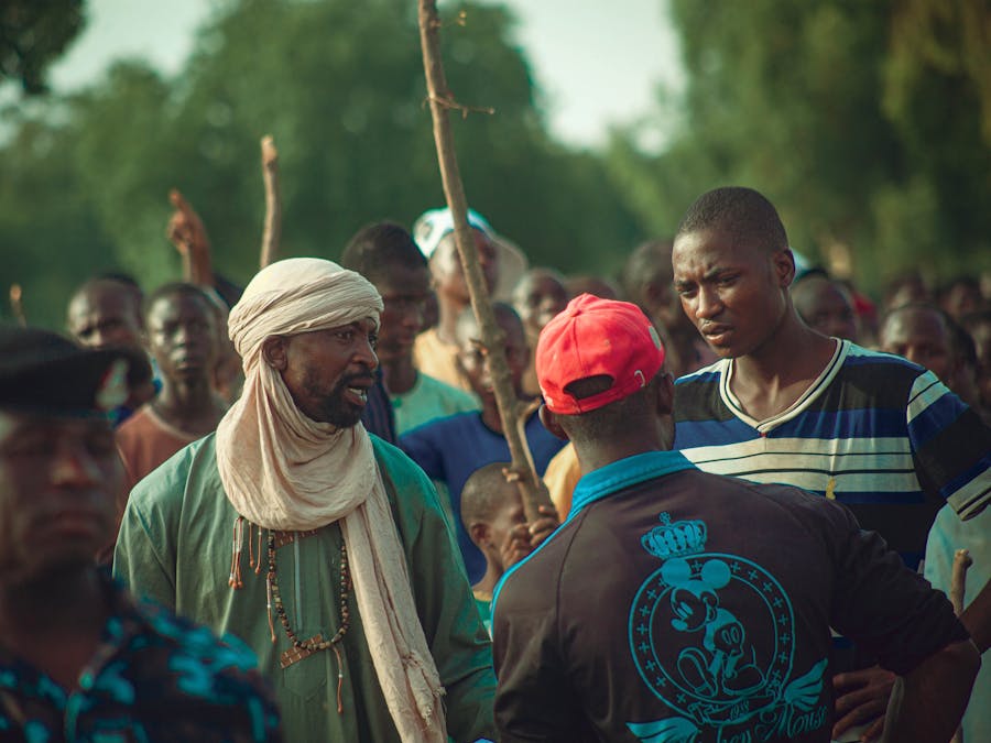 A lively outdoor gathering with people interacting in a vibrant community setting.