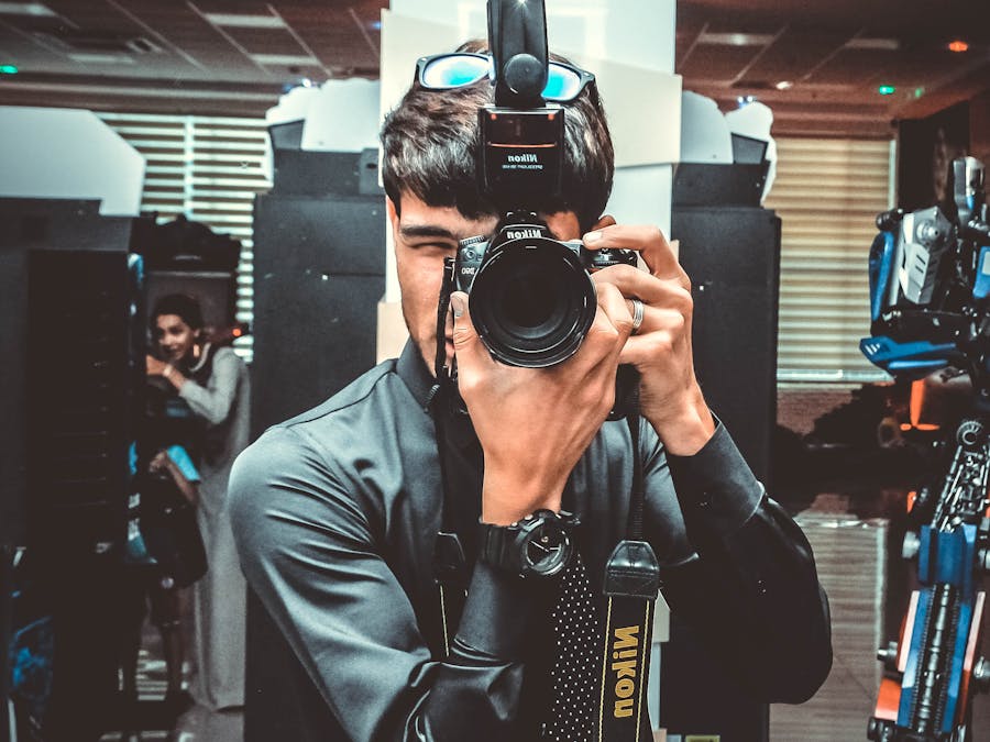 Man taking a picture with a DSLR camera indoors. Professional photography setup.