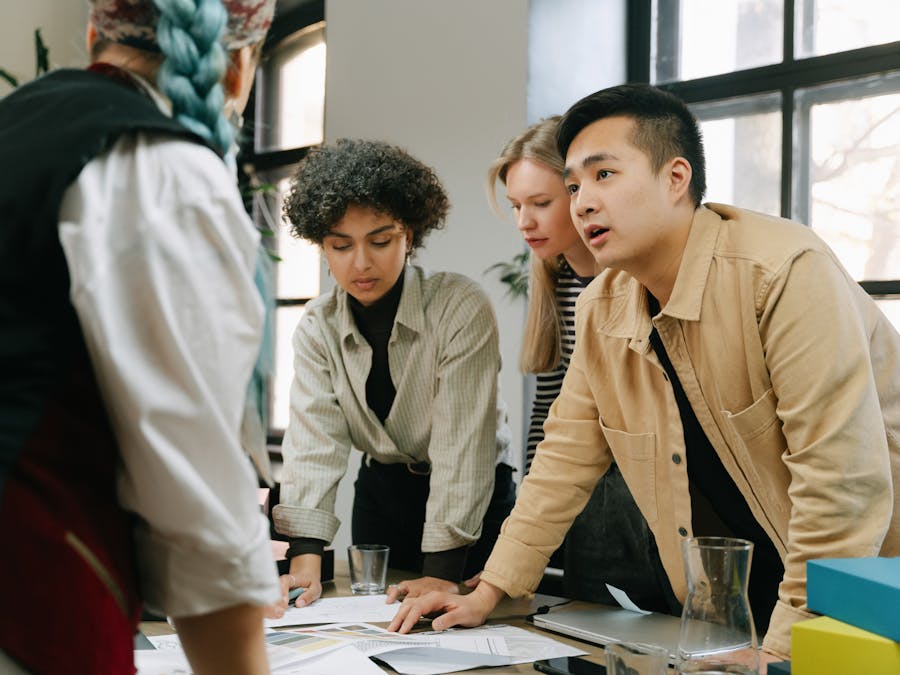 A diverse group of coworkers engaged in a collaborative meeting in a modern office setting.