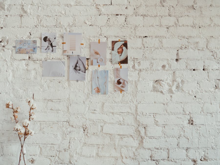 Aesthetic mood board display on a textured white brick wall with dried flowers for decoration.