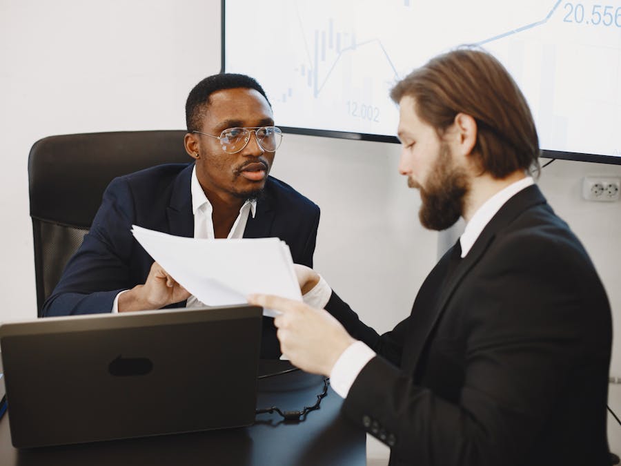 Professionals examining documents in an office business meeting setup.