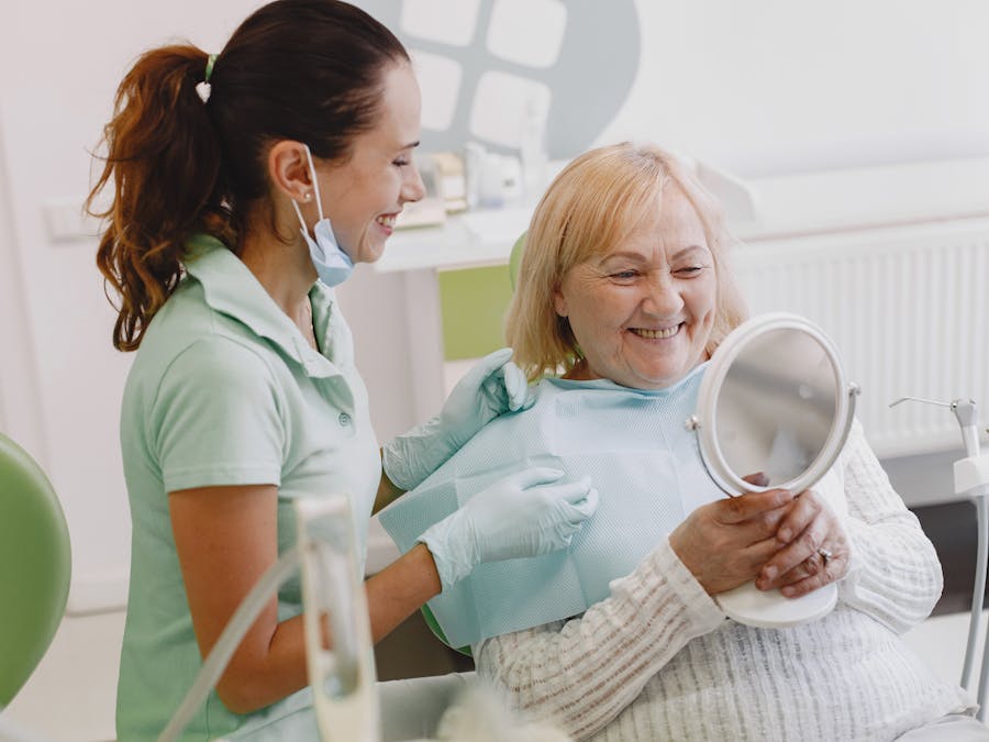 Senior patient at a dental check-up, smiling with the dentist in a modern clinic.