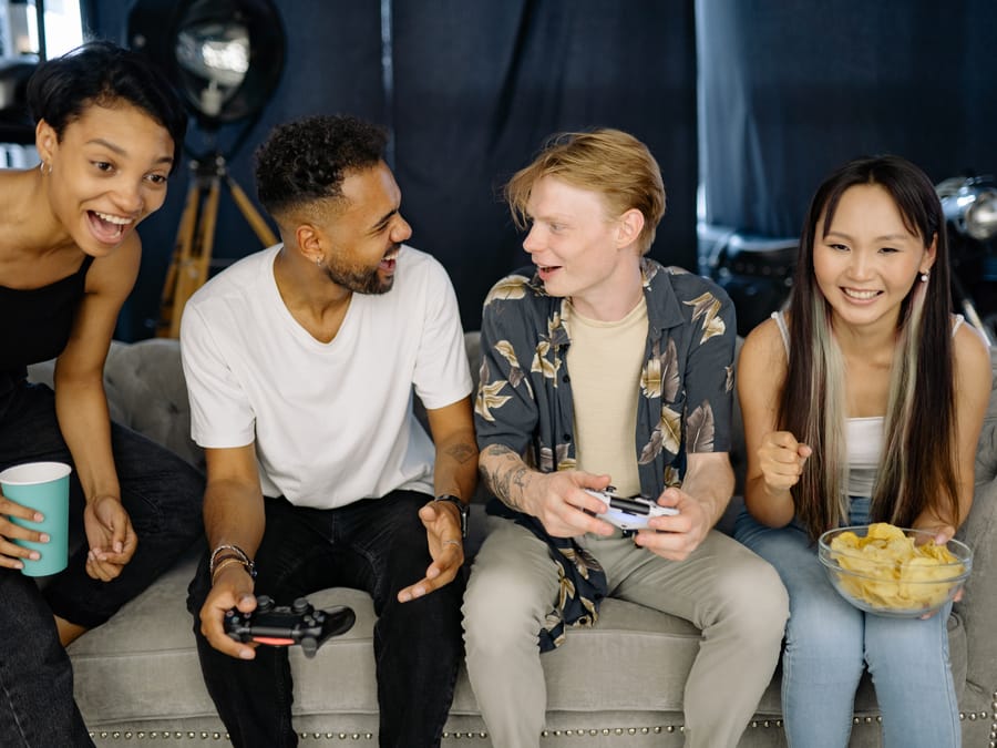 A group of diverse friends enjoying a video game session together, laughing and bonding indoors.