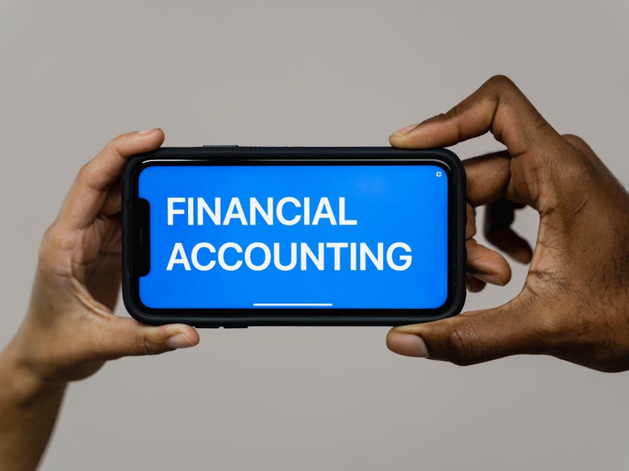 Close-up of hands holding smartphone displaying 'Financial Accounting'.