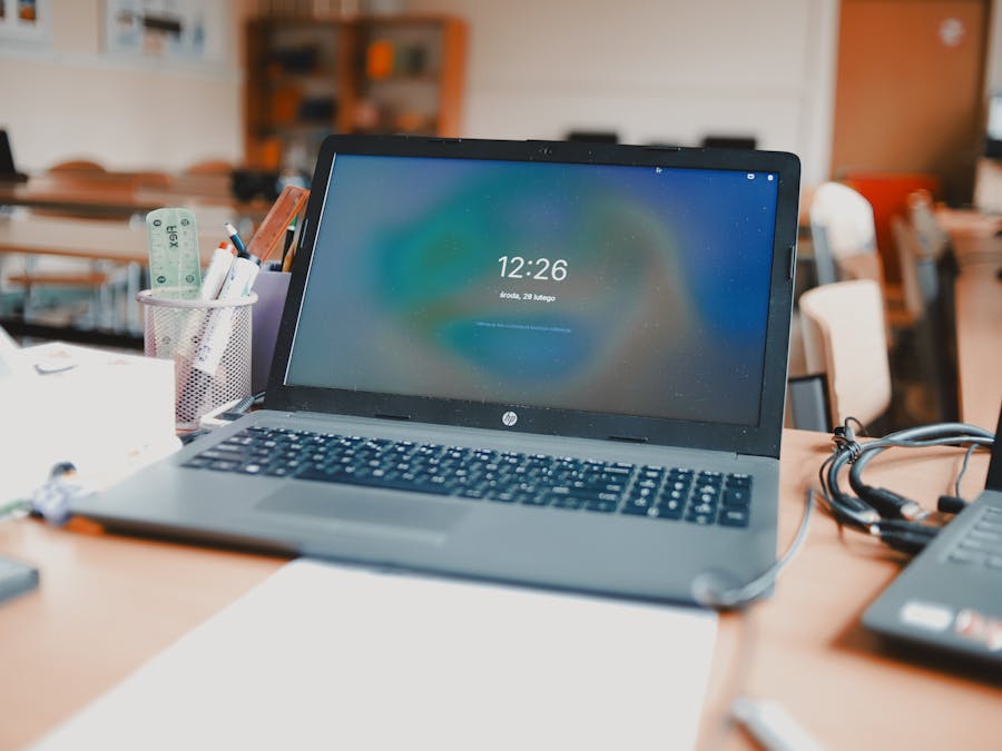 A classroom setting featuring laptops and desks, capturing a modern educational environment.