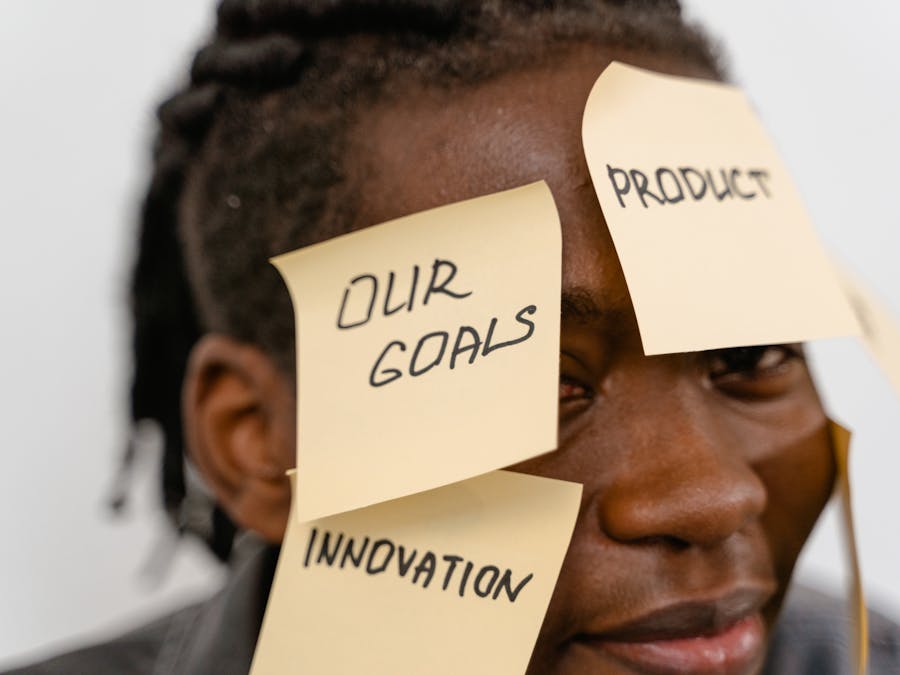 Close-up of person with sticky notes on forehead, symbolizing creative brainstorming and innovation.