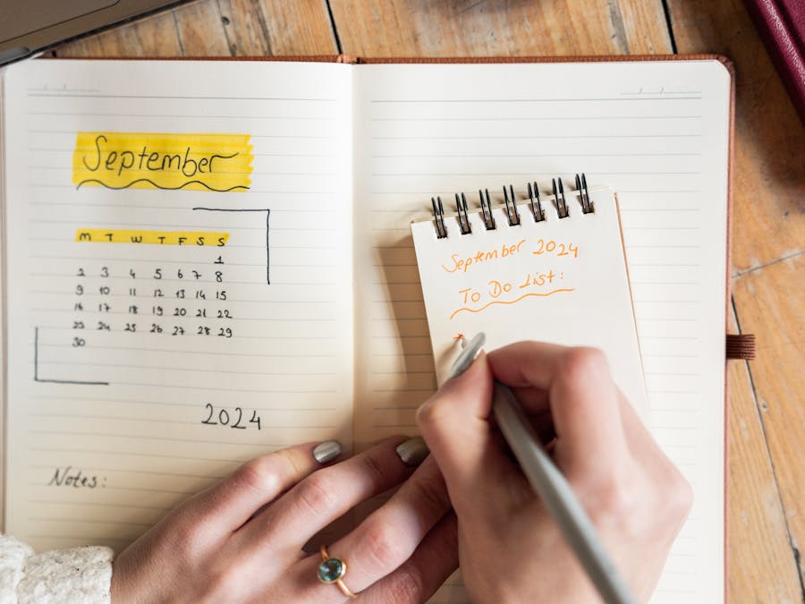 Close-up of a woman writing a to-do list for September 2024 in a notebook. Concept of organization.