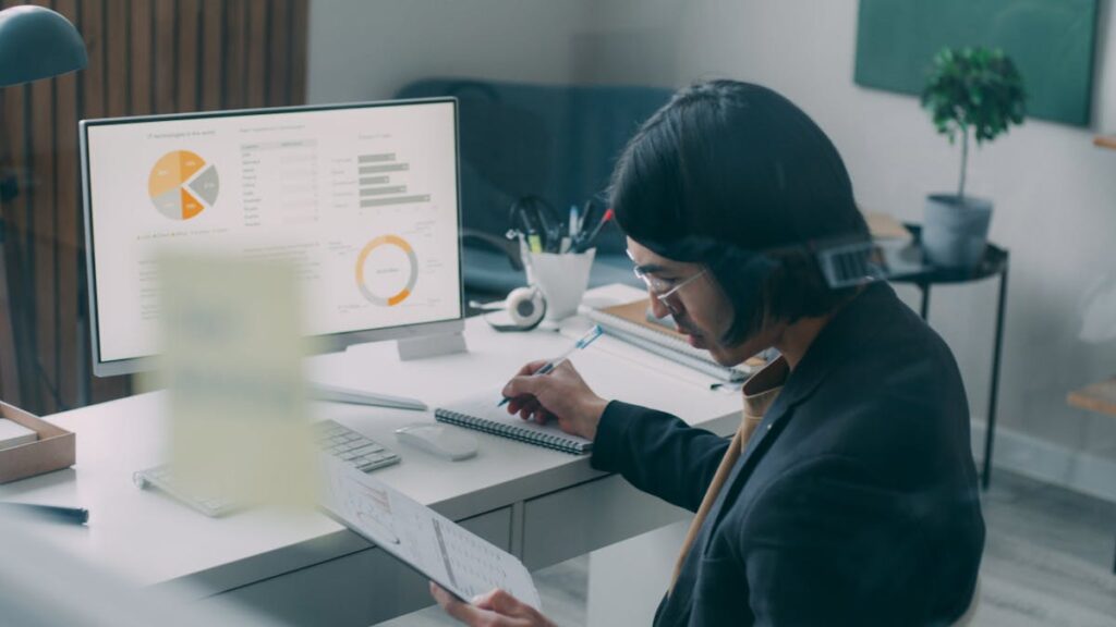 Business person reviewing analytics and charts at a modern office desk.