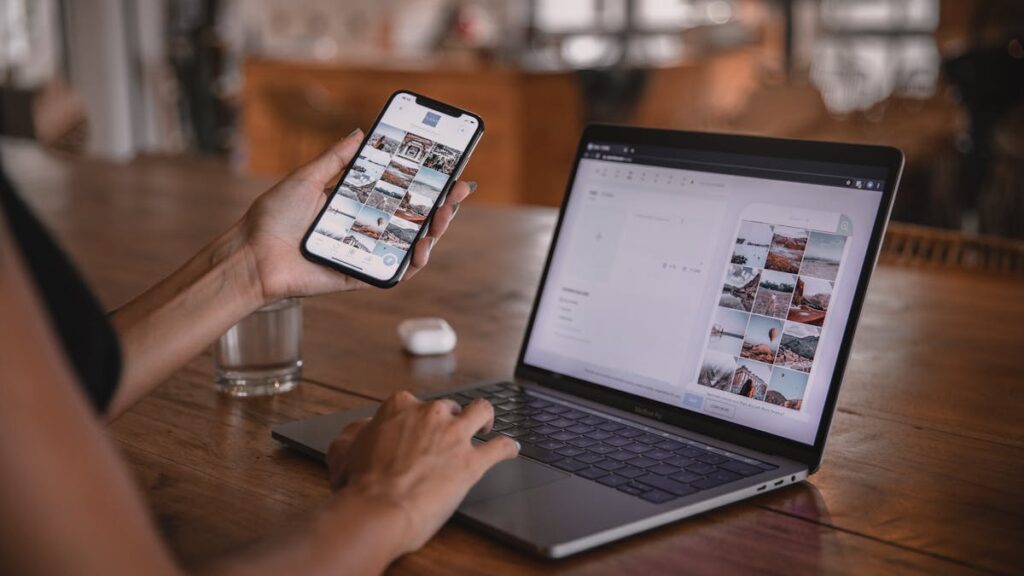 Woman edits social media content on phone and laptop at a cafe in Bali.