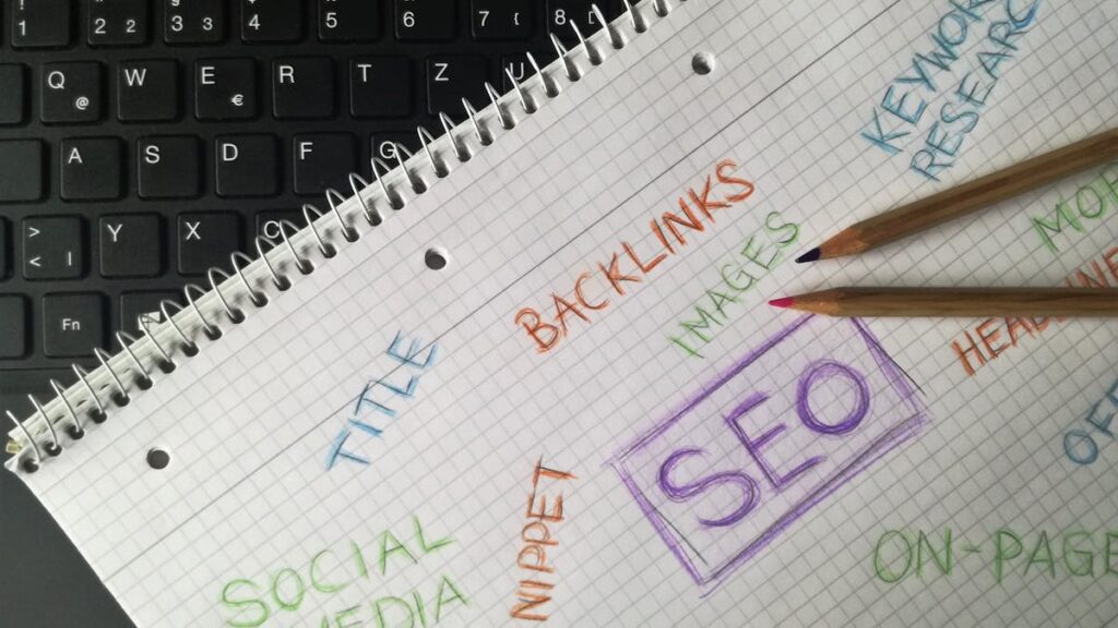 Close-up of notebook with SEO terms and keywords, highlighting digital marketing strategy.