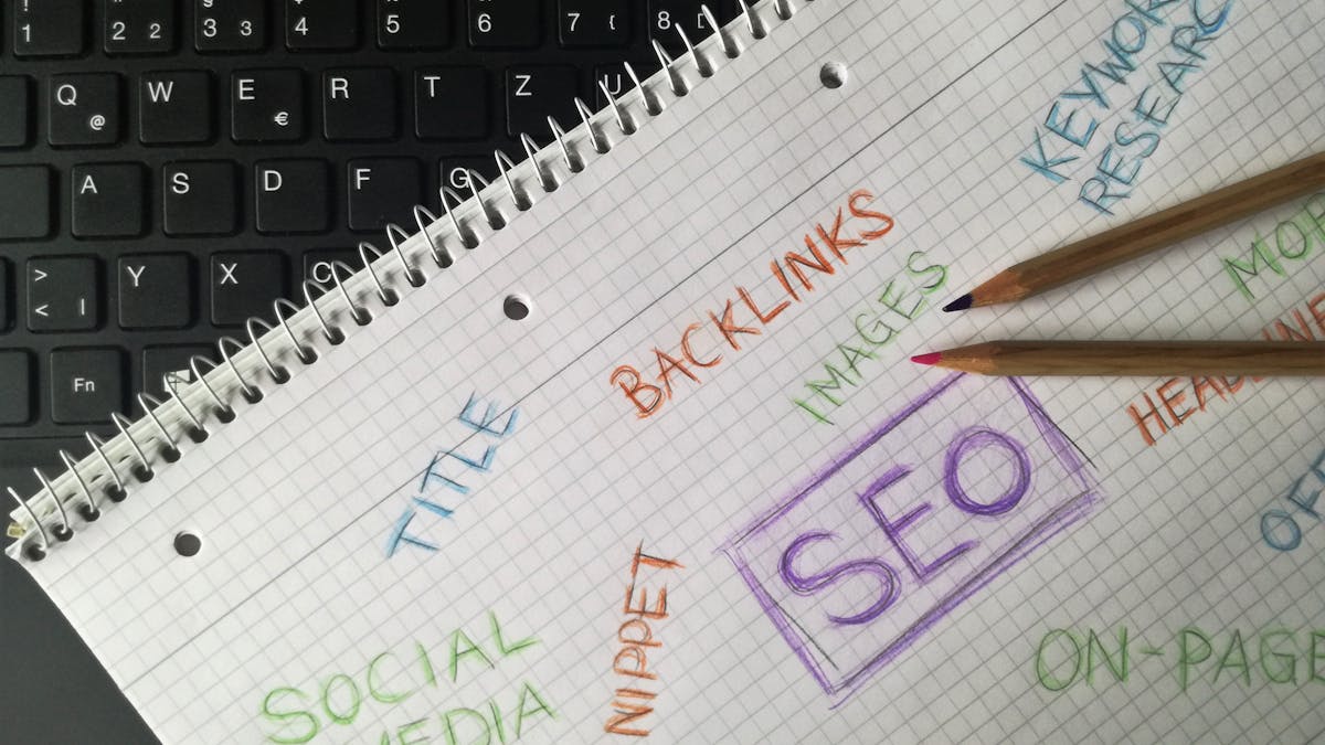 Close-up of notebook with SEO terms and keywords, highlighting digital marketing strategy.