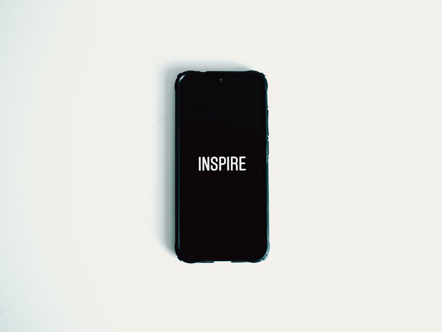 Mobile phone with 'Inspire' text on screen against a white background.