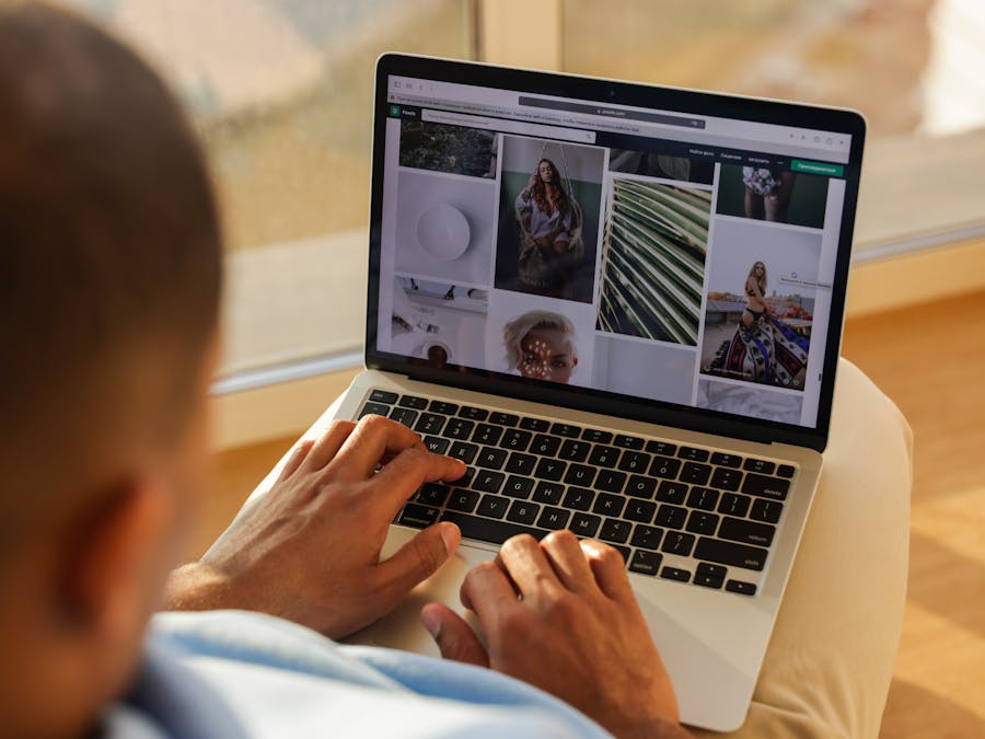 Close-up of a person using a laptop indoors while browsing a photography portfolio.