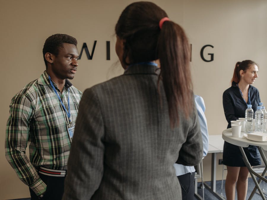 A diverse group of professionals networking at an indoor business seminar.