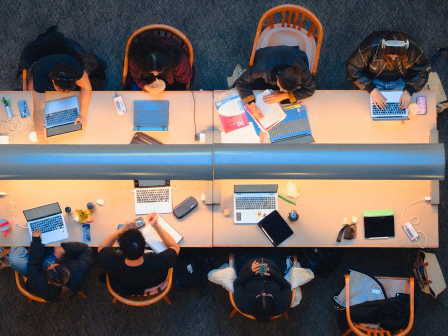 Aerial view of a study group using laptops at a library table in Kingston, Ontario.