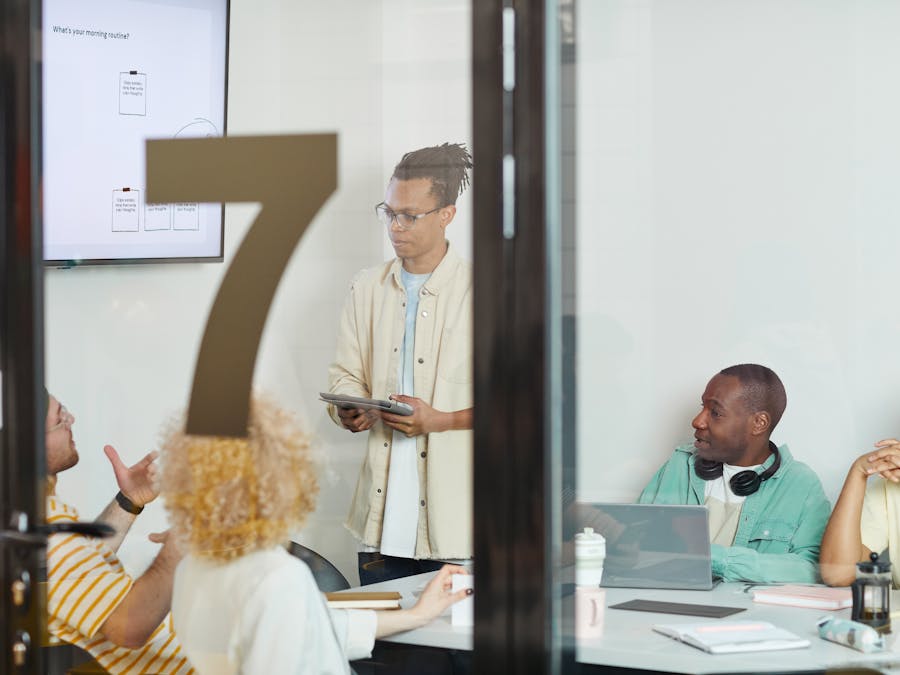 A diverse team collaborates in a modern conference room, engaging in a planning session.