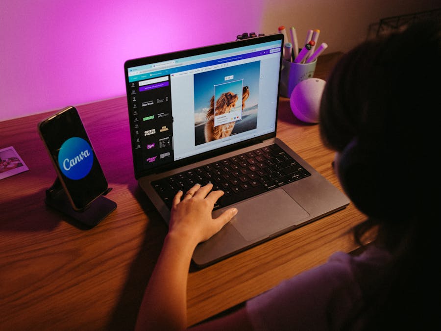 Teen working on graphic design using laptop at home with creative tools.