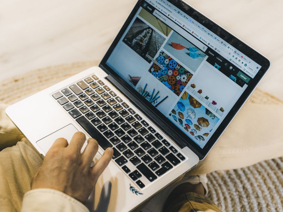 A person using a laptop to browse stock photo websites. Freelancing work in a cozy setting.