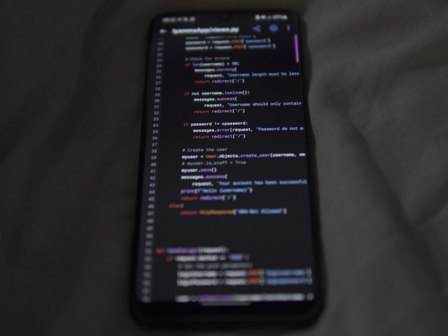 Close-up of a smartphone showing Python code on the display, showcasing coding and technology.