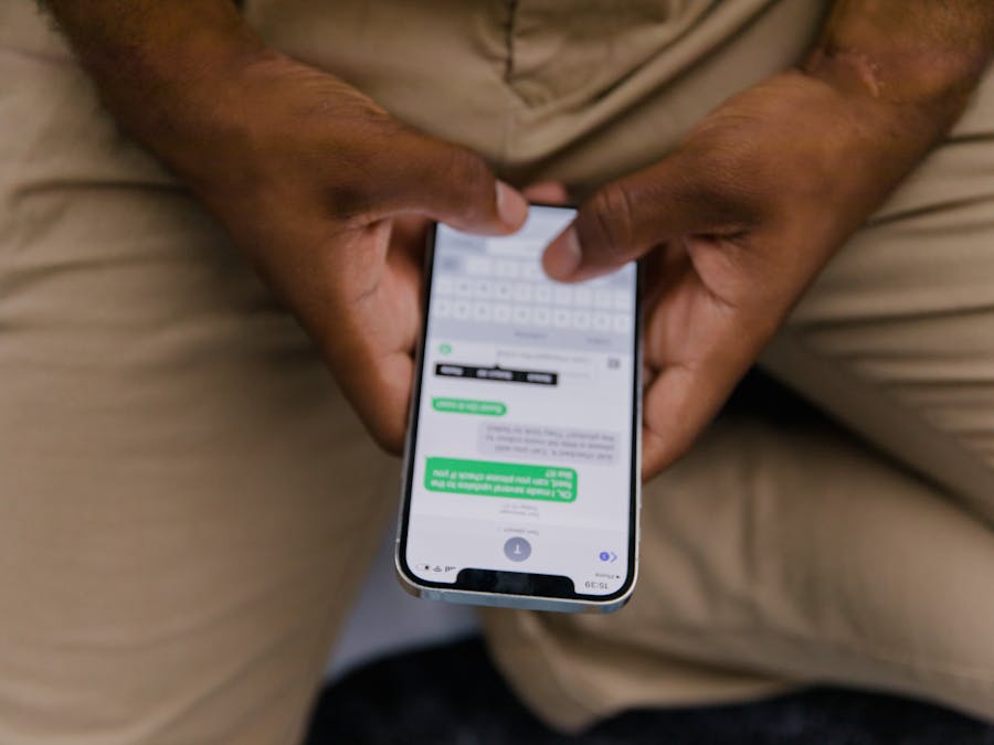Close-up view of hands texting on a smartphone, focusing on the screen displaying messages.