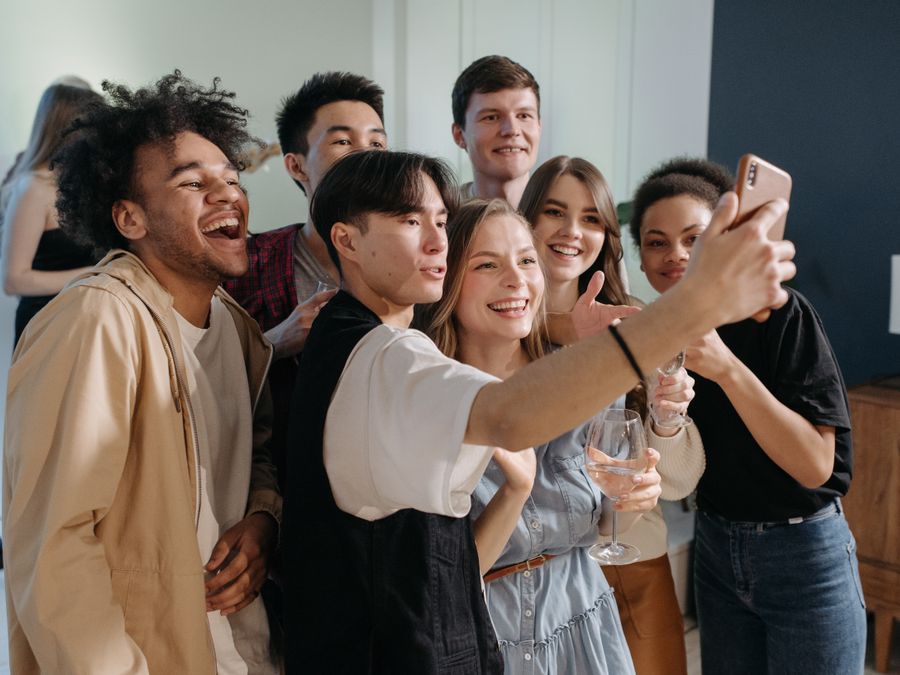 A diverse group of friends taking a cheerful selfie together indoors.
