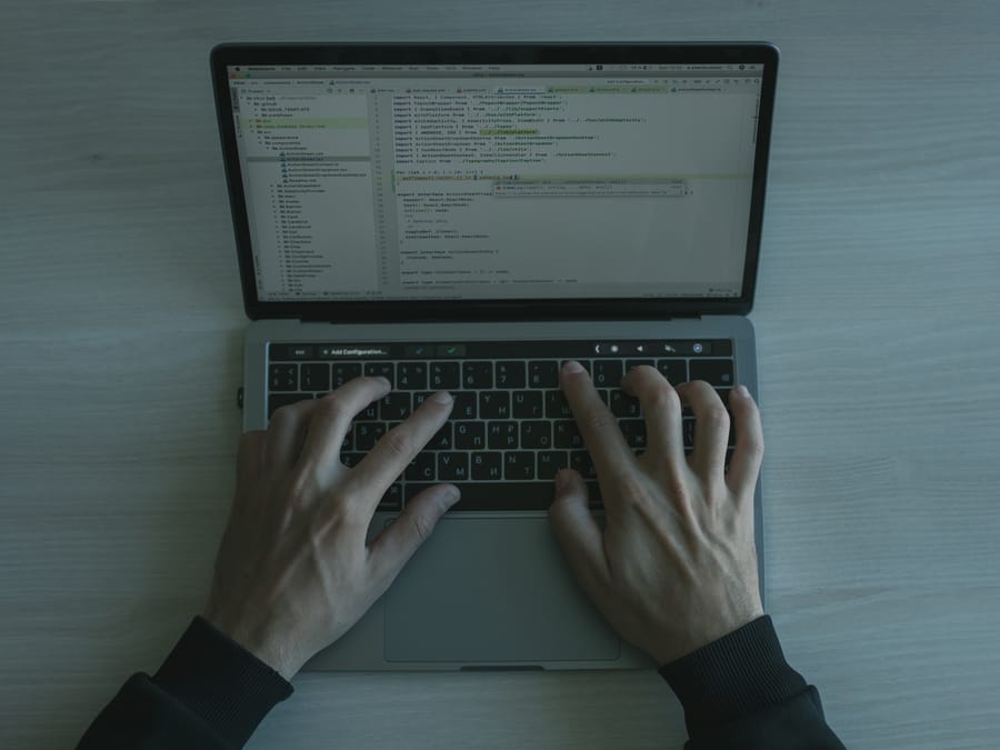 Close-up view of a programmer coding on a laptop, showcasing modern software development.