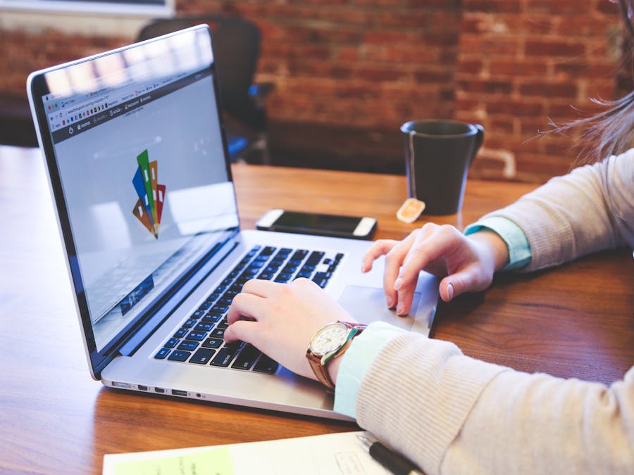 Woman working on design project using laptop at modern workspace indoors.