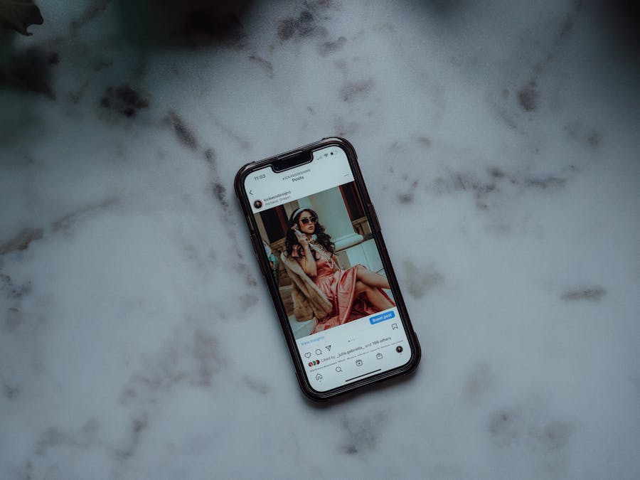 A smartphone showing an Instagram post against a marble background, showcasing modern social media use.