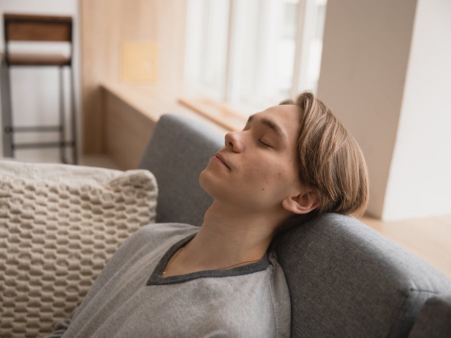 Young man relaxing on a comfortable sofa at home, enjoying a peaceful moment indoors.