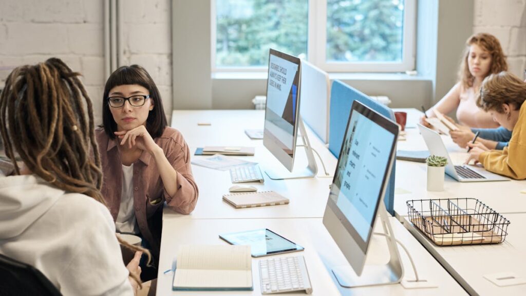 Diverse group of women working together in a modern office setting, fostering teamwork and creativity.