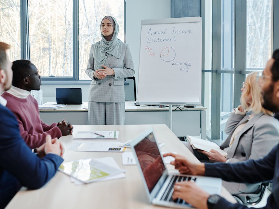 Professionals engaged in a business meeting with a focus on income presentation.