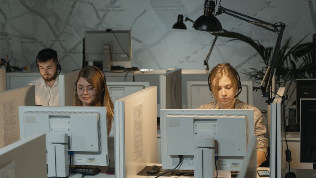 Call center agents working diligently with computers and headphones, providing customer support.