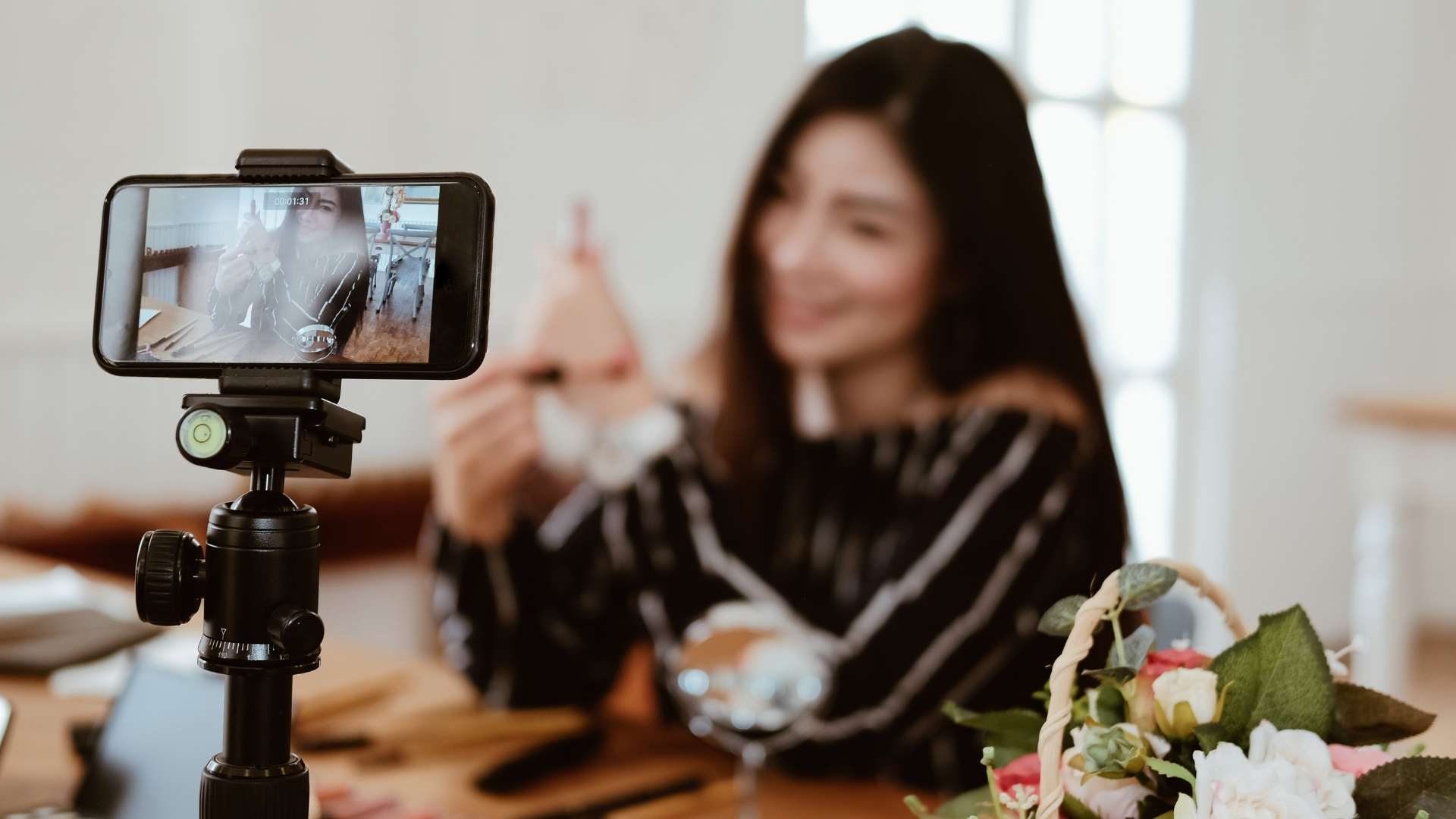 Creator filming a social media video ad with a smartphone on a tripod
