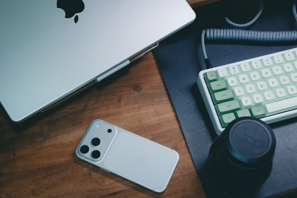 Creator workspace with smartphone, laptop, keyboard, and camera lens for social media video content