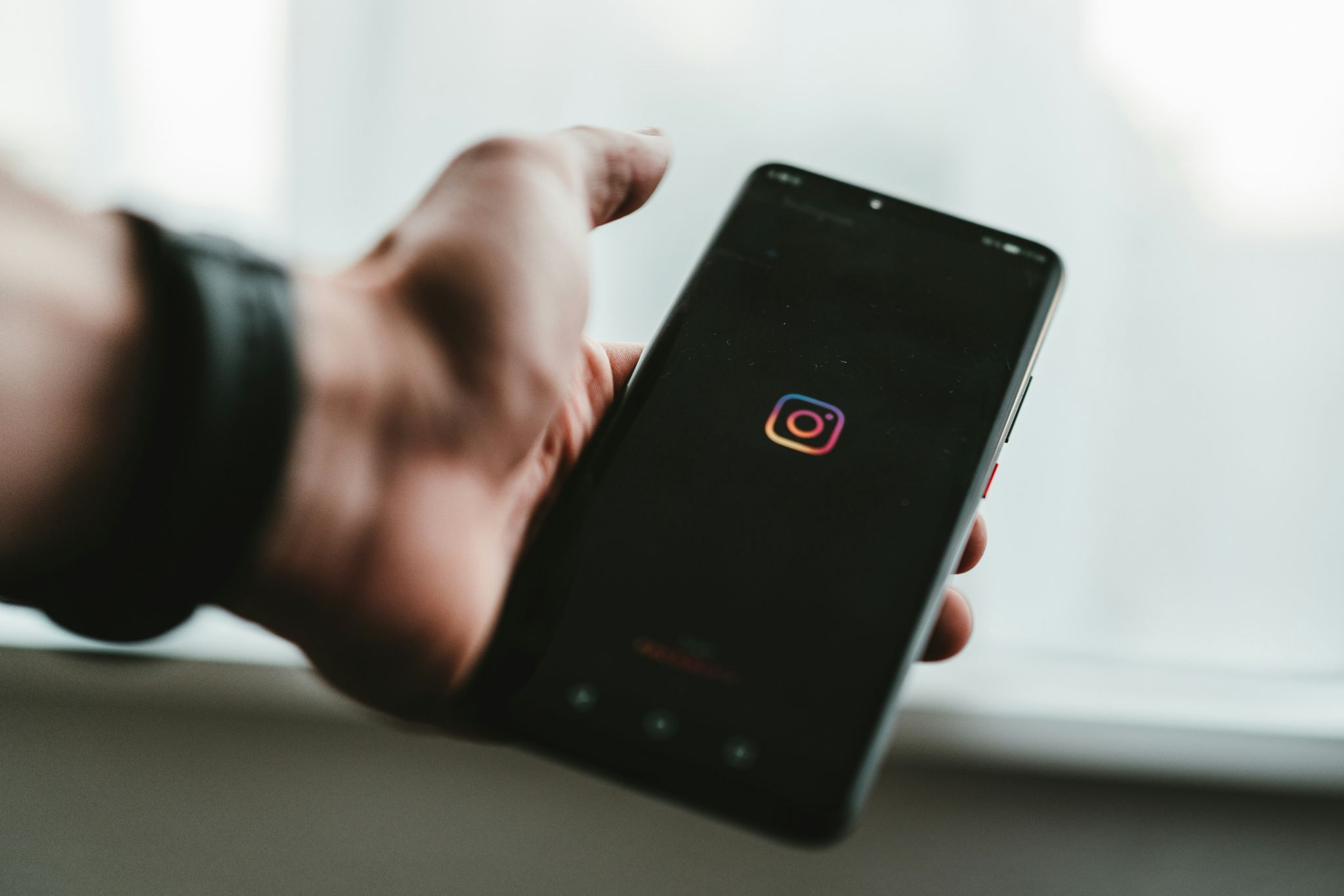 Person holding a smartphone with the Instagram app open