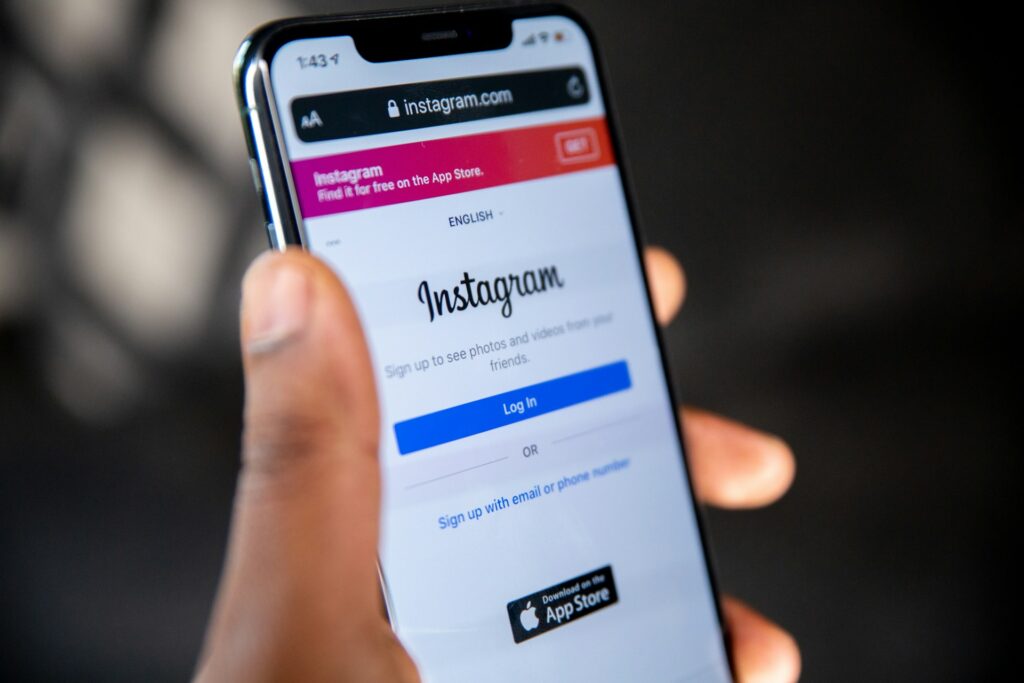 Person holding a smartphone displaying the Instagram login page
