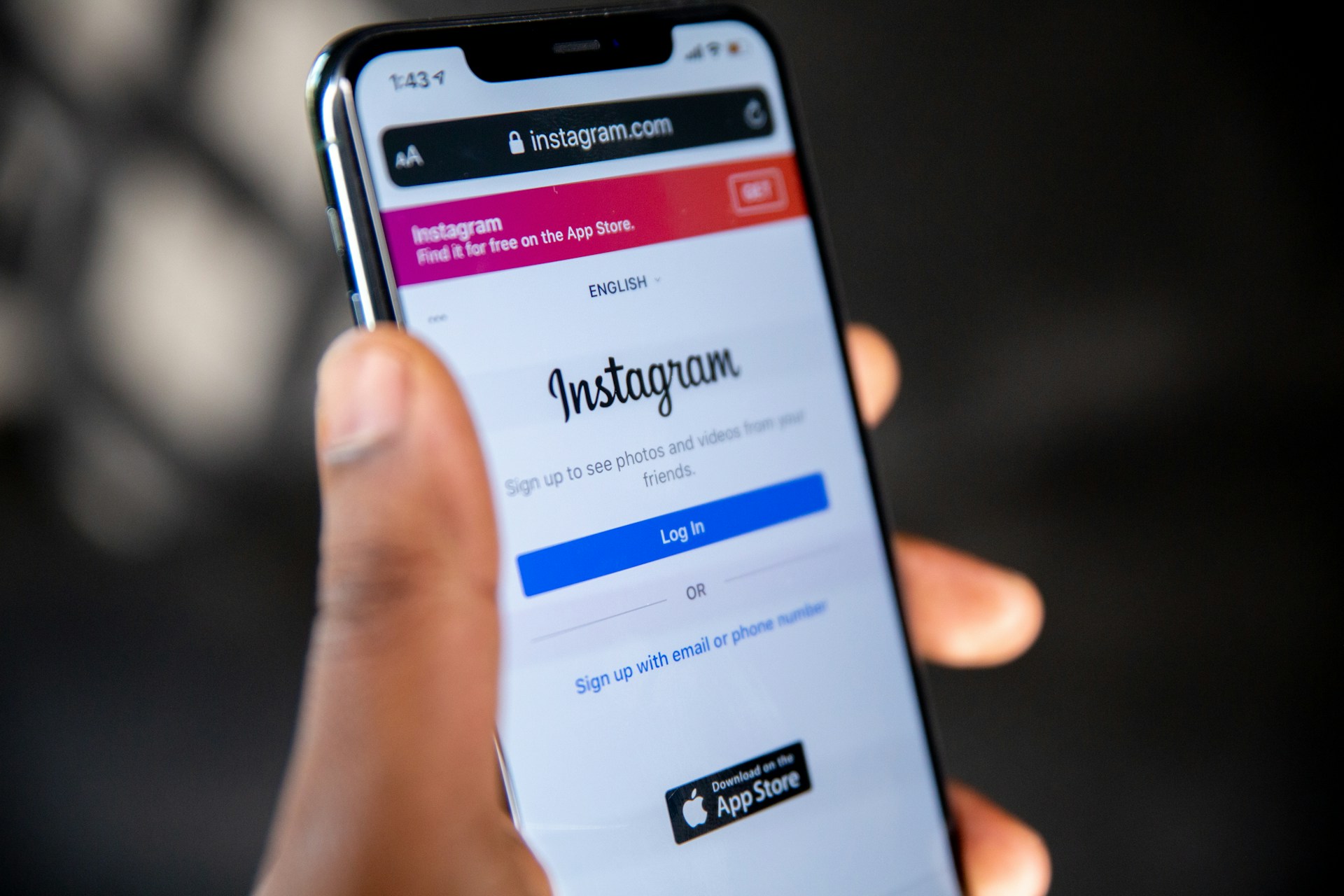 Person holding a smartphone displaying the Instagram login page