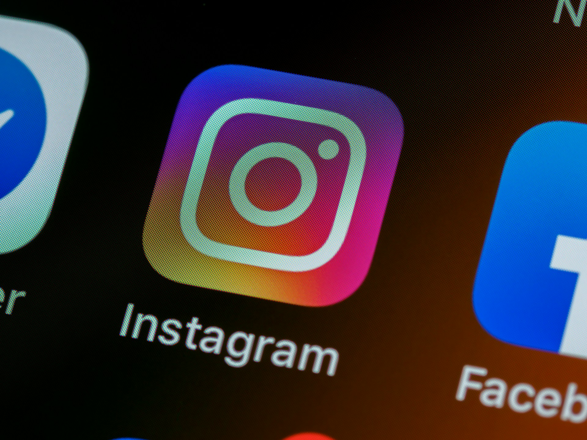 Close-up of the Instagram app icon on a smartphone screen next to other social media apps